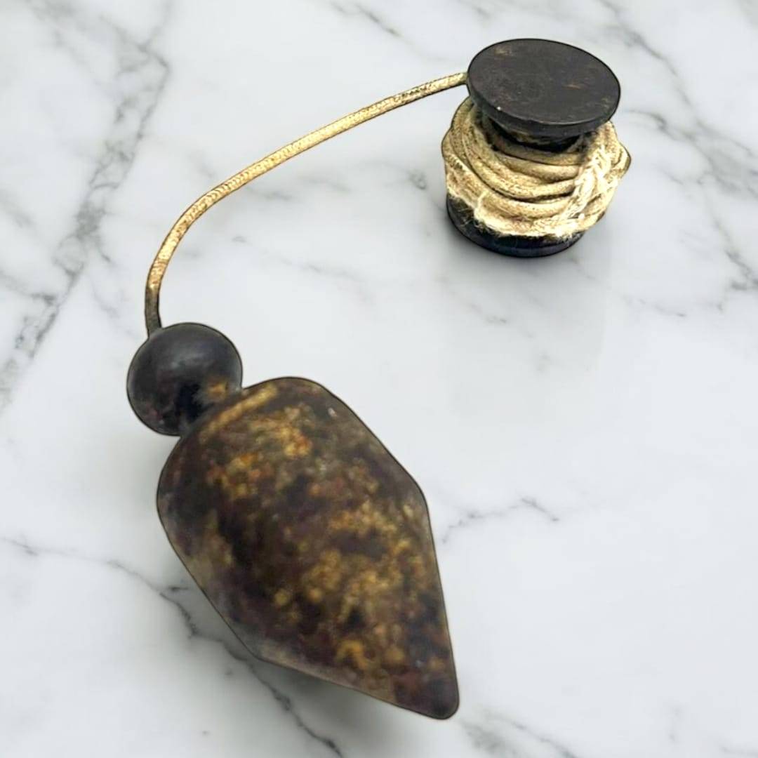 Plomada antigua: herramienta de precisión vertical histórica con cuerda enrollada, ideal para decoración vintage en hogar o jardín.