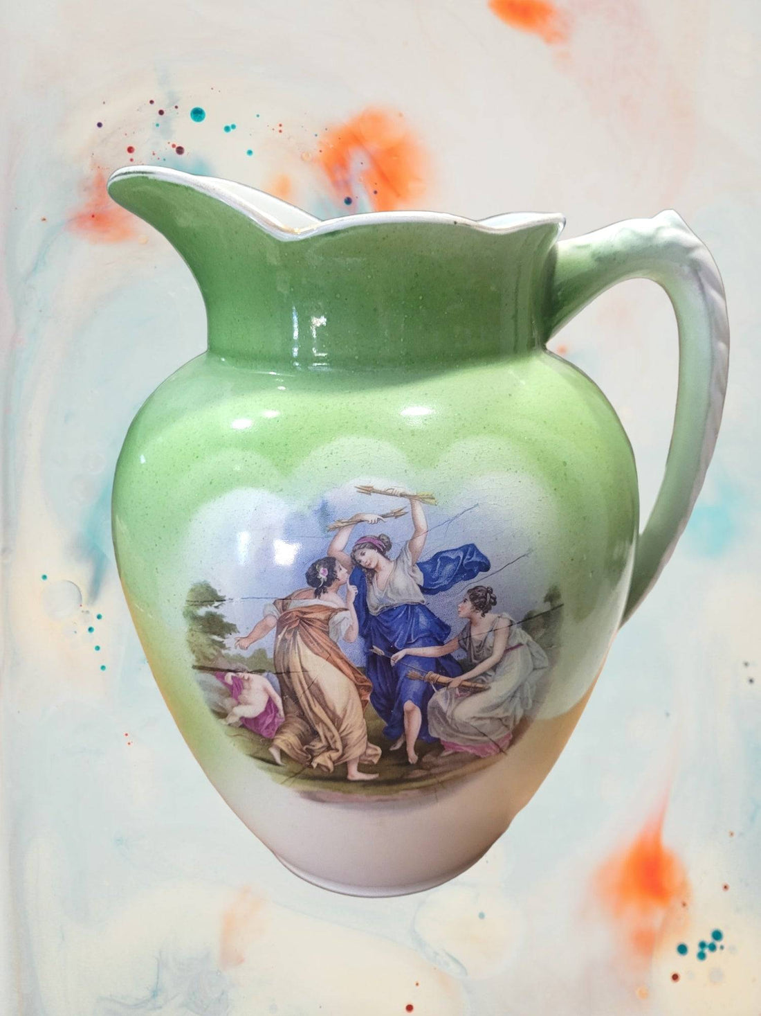 Jarra de aguamanil porcelana Cartuja de Sevilla vintage con escena clásica de mujeres danzando, ideal para decoración de estilo antiguo.