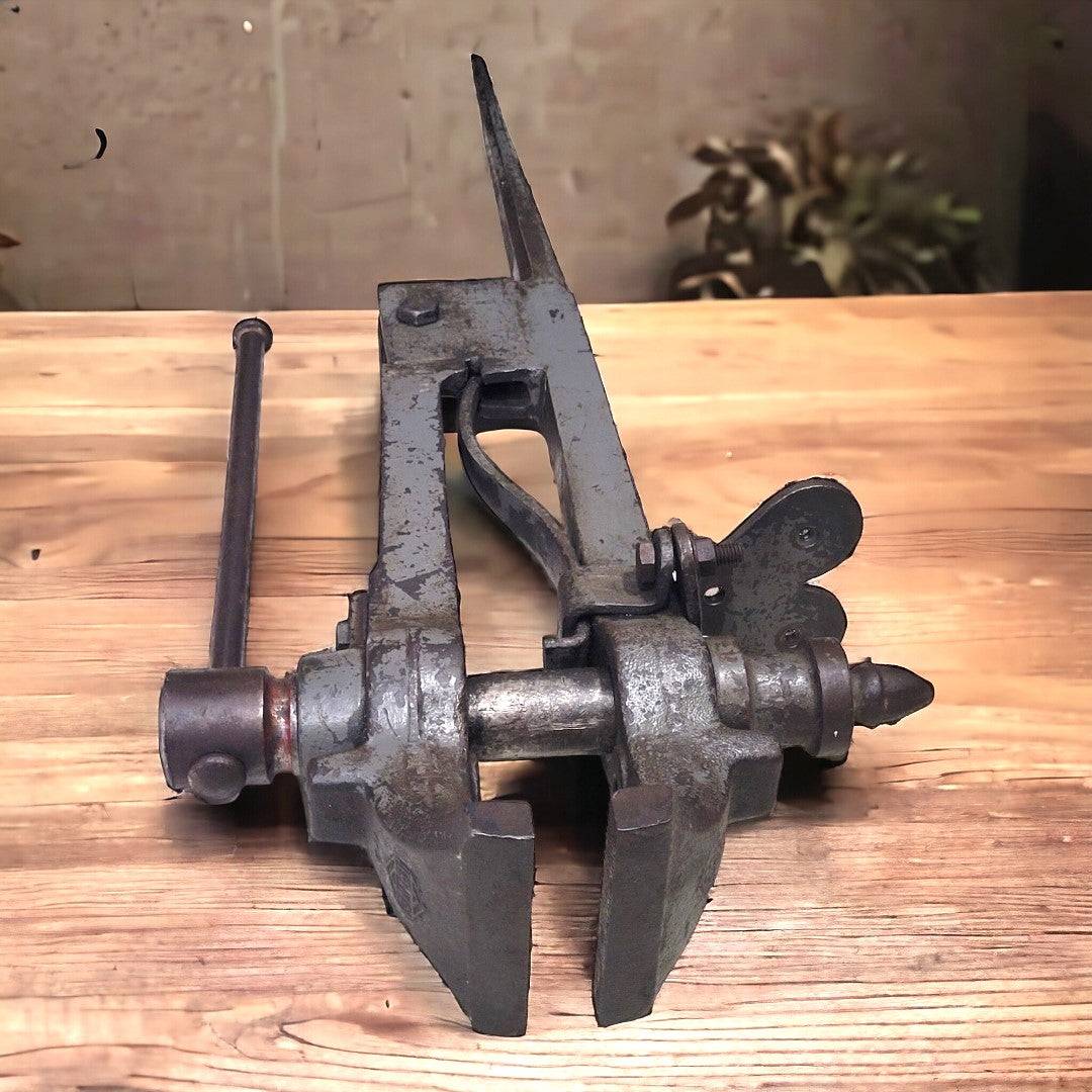 Tornillo herrero acero de fundición montado sobre madera clara, ideal como decoración rústica para taller o fragua artesanal.