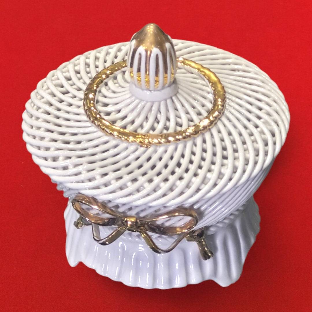 Joyero de porcelana trenzada hecho a mano en Manises, Valencia, con tapa decorativa y lazo dorado, ideal para decoración de hogar elegante.