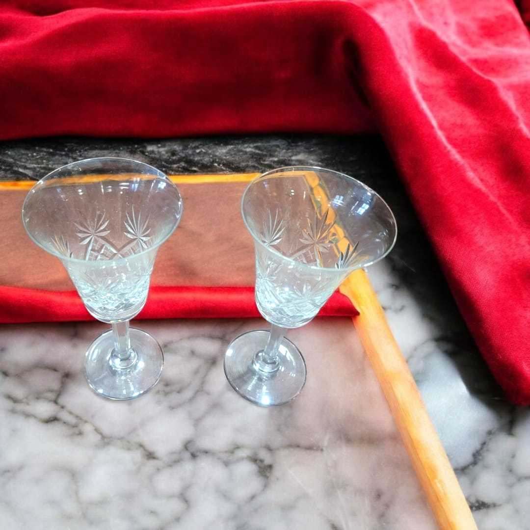Copas de cristal de Bohemia vintage, juego de 2 elegantes con tallado clásico sobre mármol y tela roja, ideales para decoración de mesa.