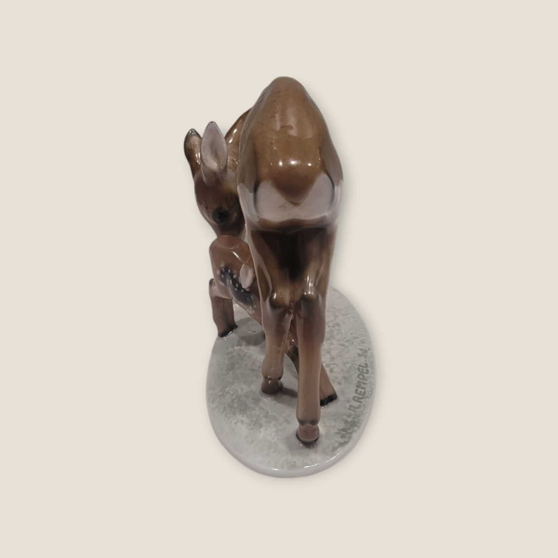 Figura de porcelana Rosenthal representando una cierva y su cría en tonos marrones sobre base ovalada. Detalles pintados a mano.