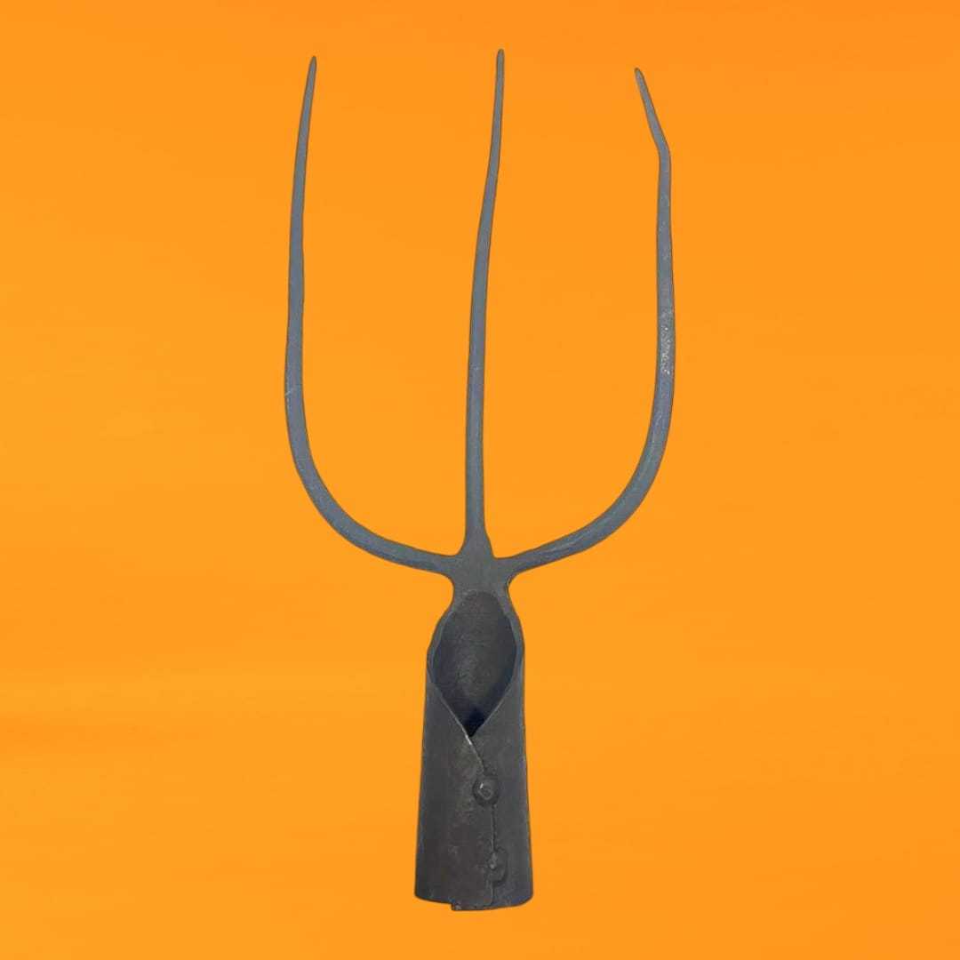 Horca tridente antigua de hierro forjado con tres púas, perfecta para decoraciones rústicas en jardines o interiores vintage.