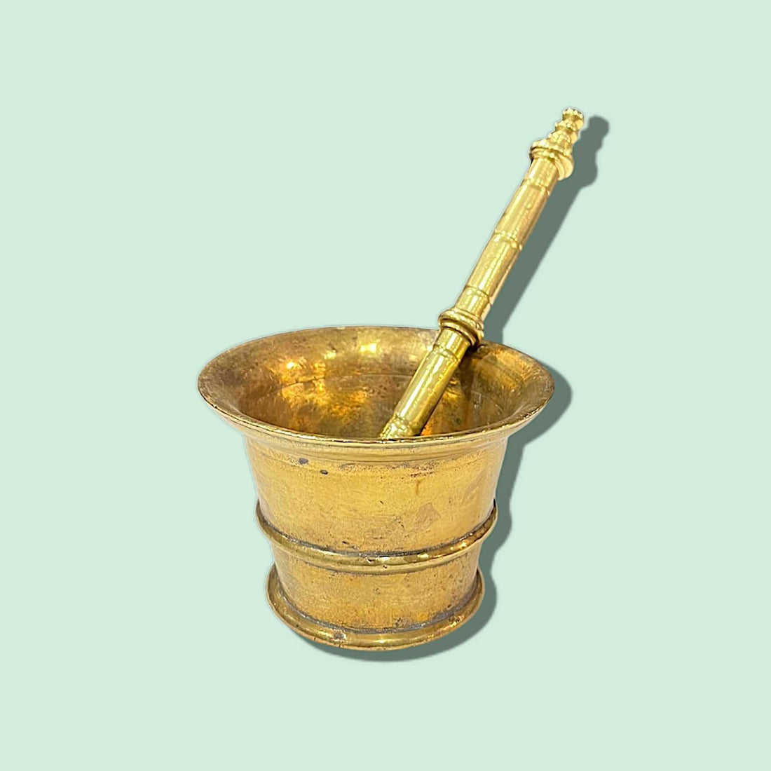 Mortero antiguo de bronce con diseño clásico y pestillo, ideal para decoración vintage en cocinas o comedores. Acabado dorado con detalles ornamentales.