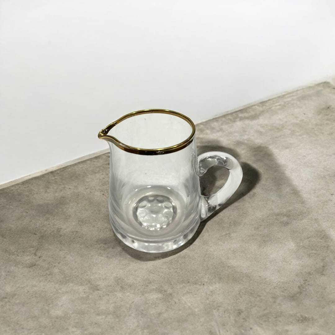 Conjunto de Cristal de Bohemia con filo de oro compuesto por jarra y 4 vasos sobre superficie de mármol. Ideal para decoración elegante en el hogar.