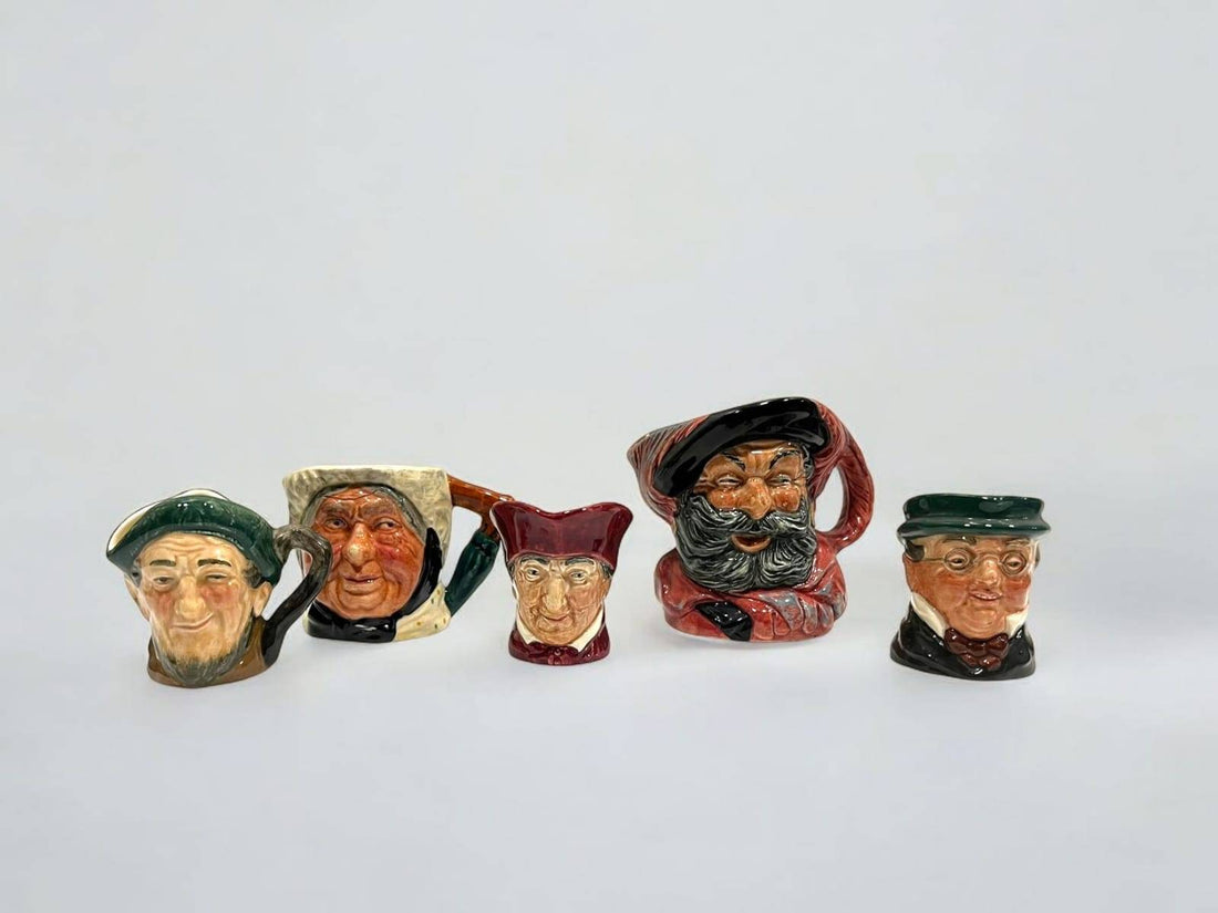 Jarras de porcelana Royal Doulton con rostros de personajes famosos como Falstaff y Mr. Pickwick, ideales para decoración vintage de interiores.
