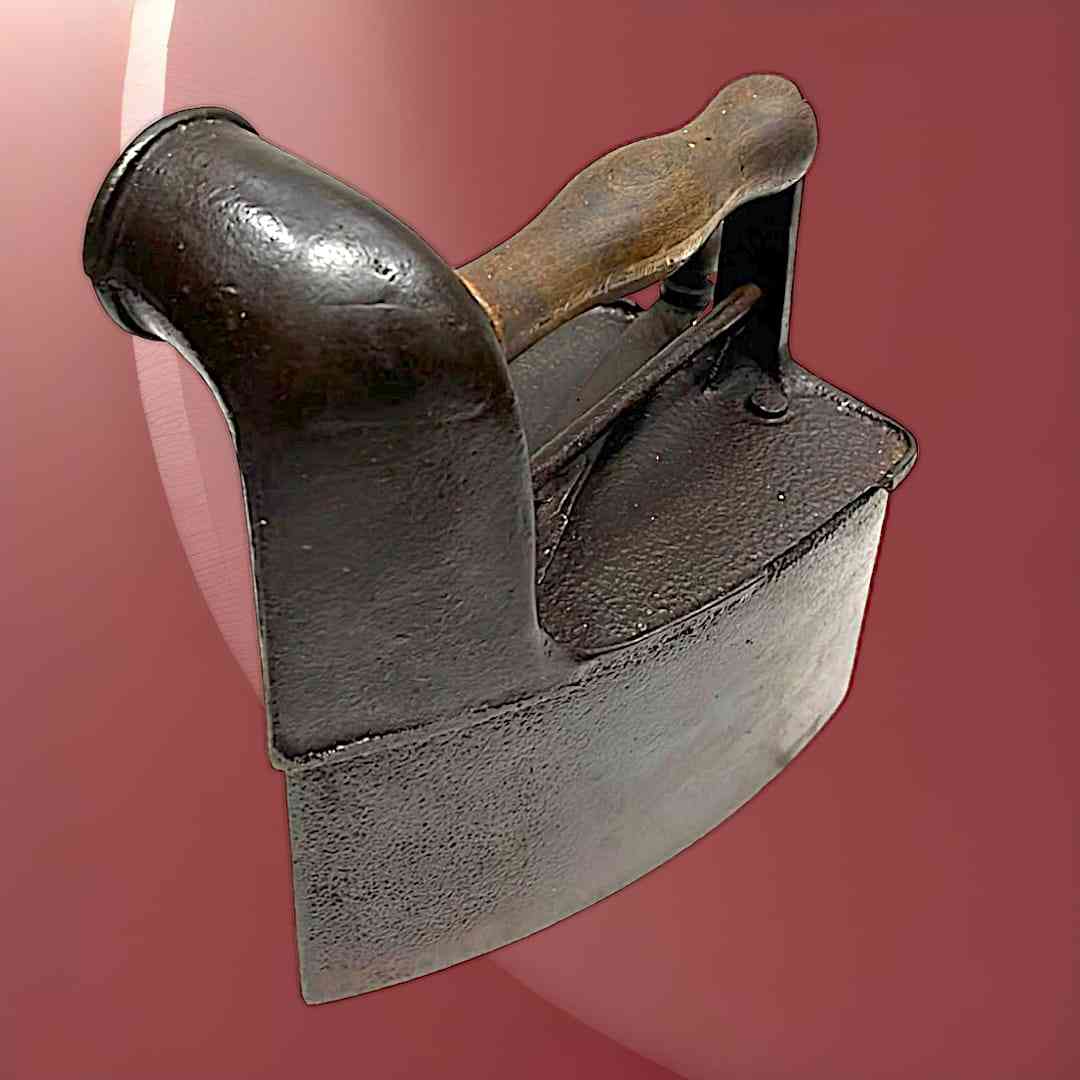 Plancha antigua de carbón con mango de madera en hierro oscuro, ideal para decoración vintage o colección única.