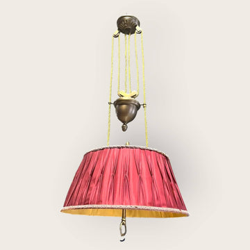 Vista lateral de lámpara de techo vintage ajustable con pantalla plisada roja y detalles dorados, ideal para ambientes acogedores y elegantes.