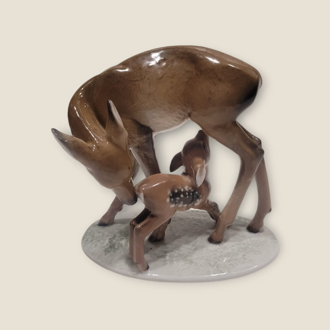 Figura de porcelana Rosenthal representando una cierva y su cría en tonos marrones sobre base ovalada. Detalles pintados a mano.