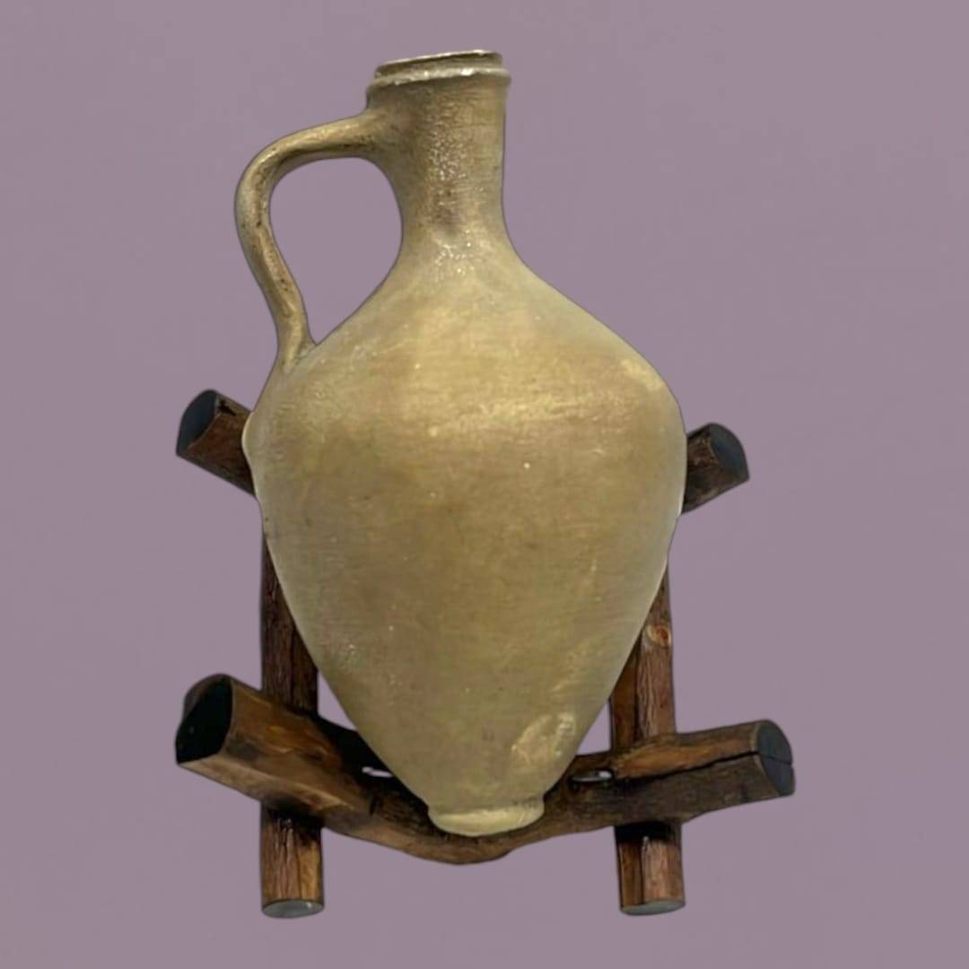 Cántara miniatura de Lebrija sobre soporte de madera rústica, ideal para decoraciones auténticas en espacios tradicionales del hogar.