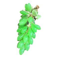 Racimo de uvas de cristal de color verde con acabado brillante, ideal para decoración artística y elegante en el hogar.