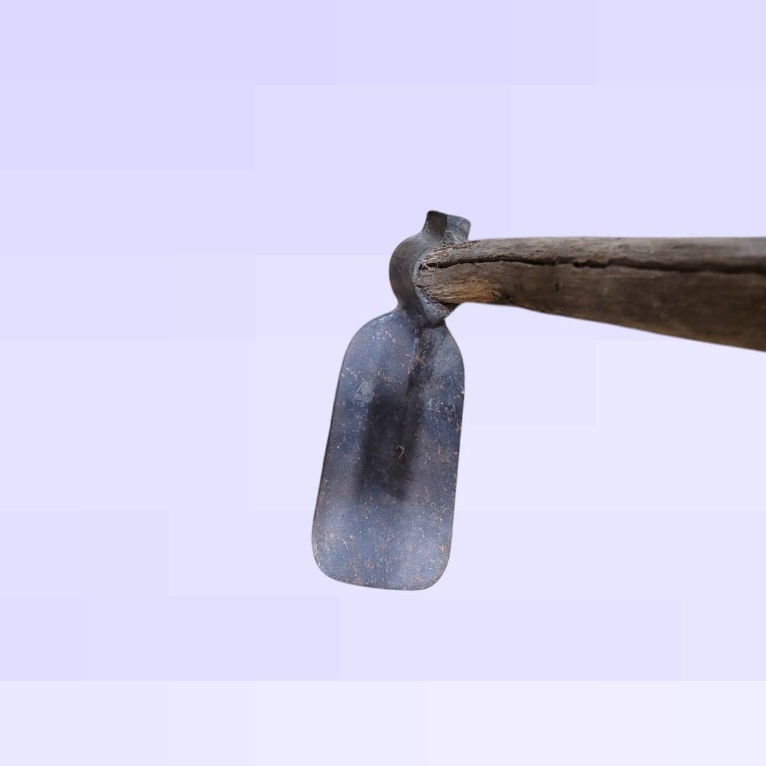 Cabeza de azada antigua de hierro forjado con mango de madera desgastado, ideal para decoración rústica en jardín o interiores vintage.
