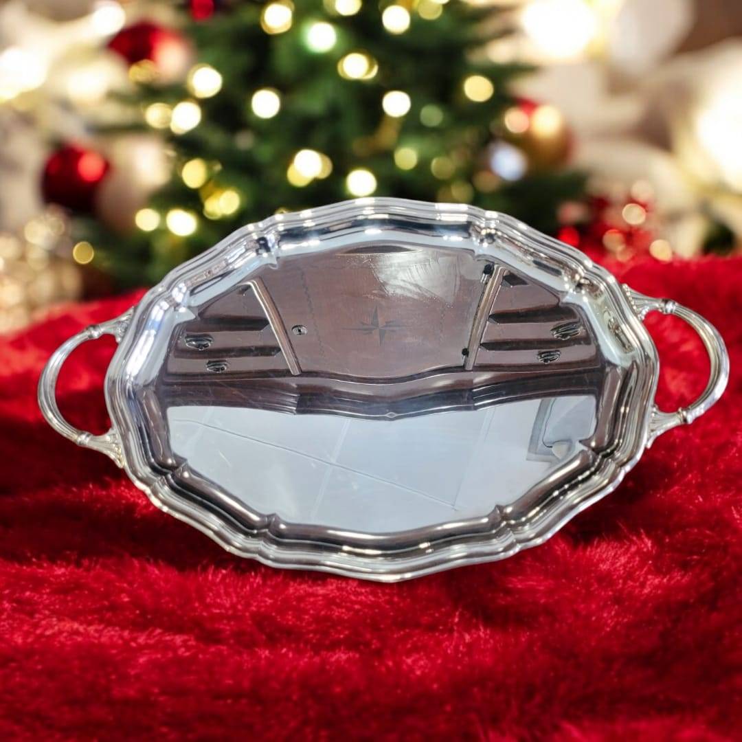 Bandeja de metal plateada con diseño elegante y funcional sobre tela roja, ideal para decoración de hogar en Navidad.