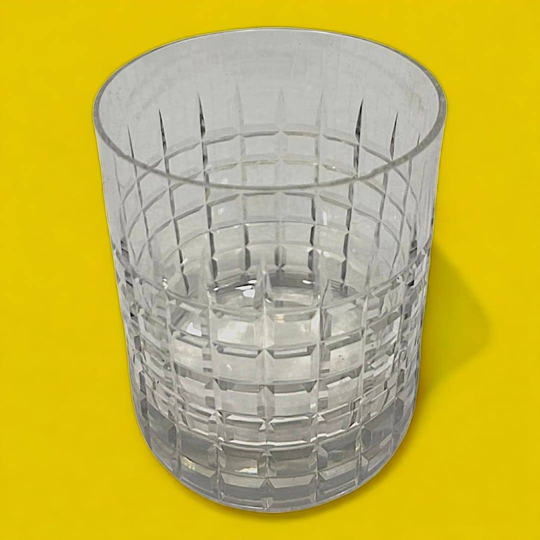 Coctelera de cristal con tapa de plata y seis vasos a juego sobre fondo verde, ideal para decoración elegante en eventos en casa.