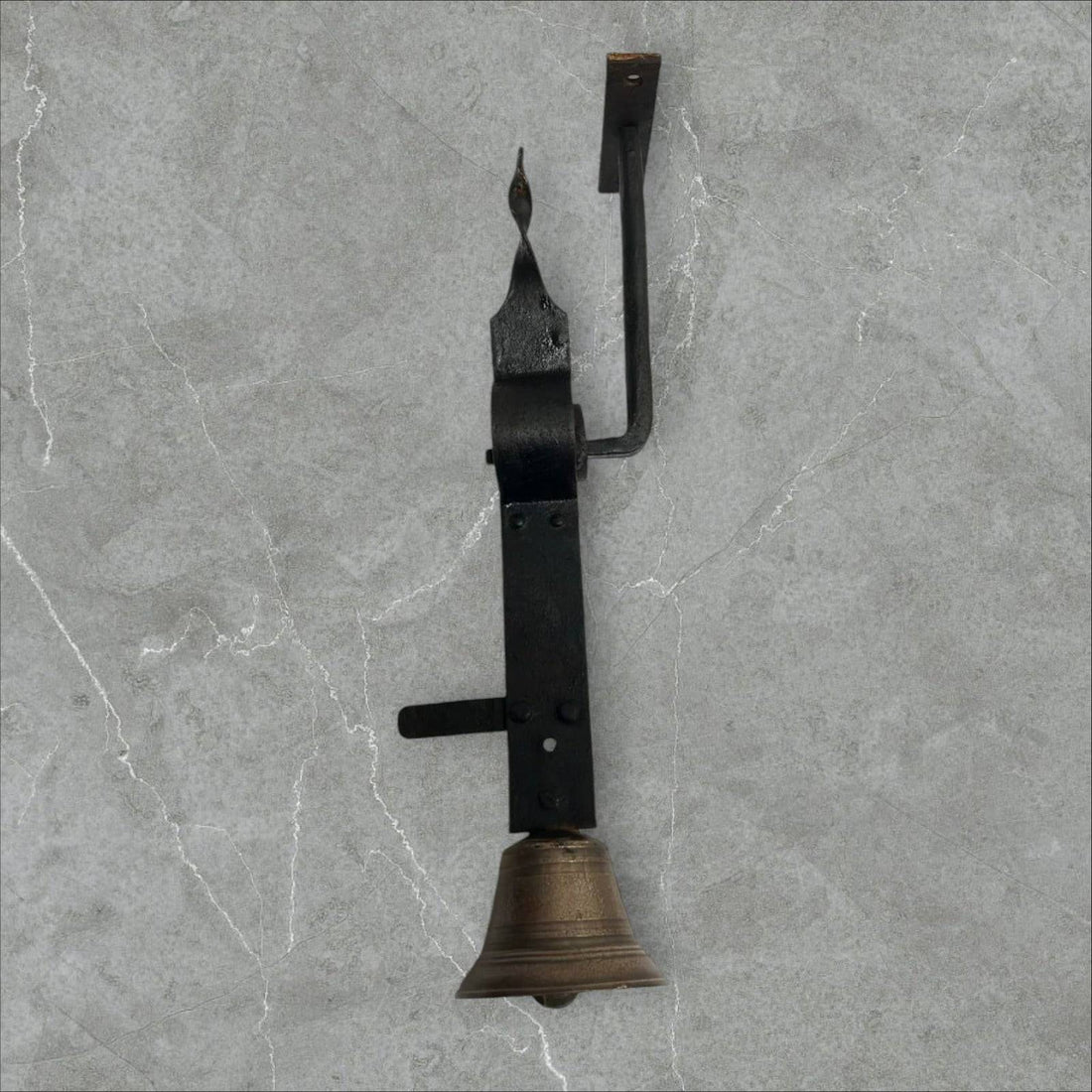 Campanilla antigua de bronce y hierro montada en pared, ideal para decoración vintage en entradas de hogar o negocio.