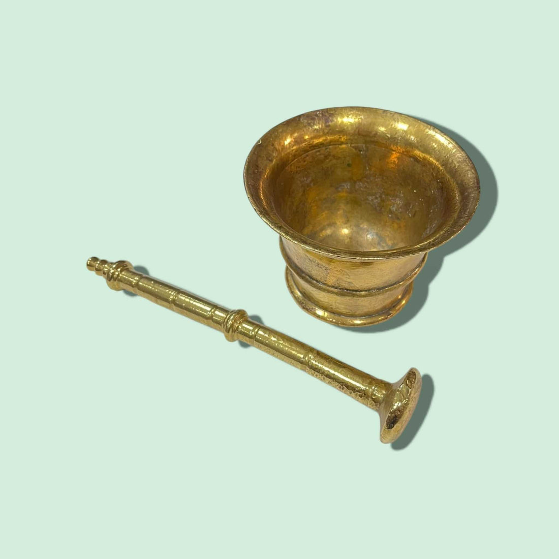 Mortero antiguo de bronce con diseño clásico y pestillo, ideal para decoración vintage en cocinas o comedores. Acabado dorado con detalles ornamentales.