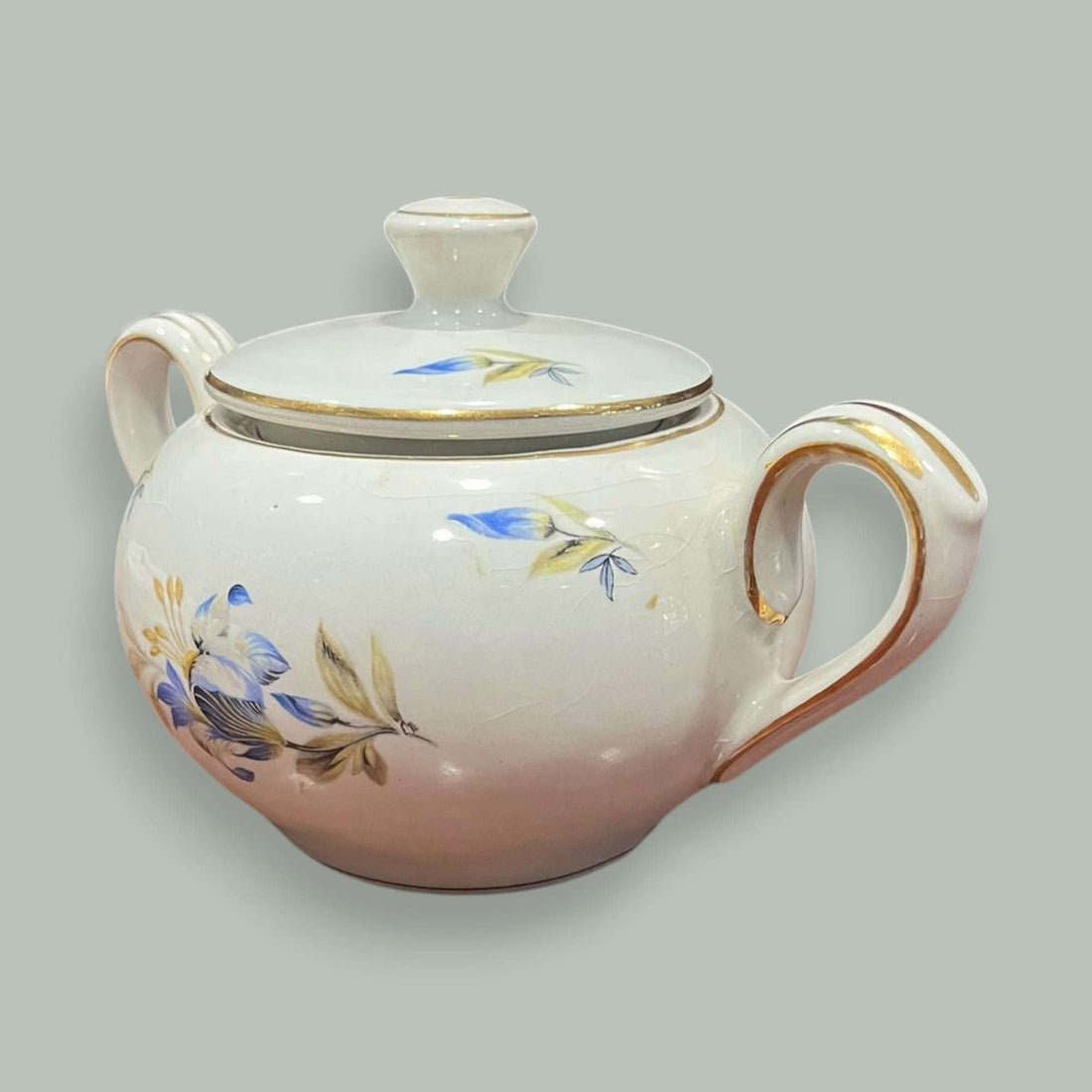 Azucarero Pickman de porcelana blanca con flores azules y detalles dorados.