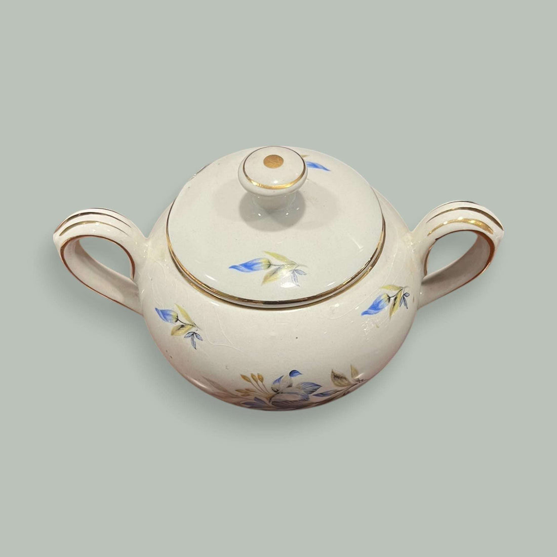 Azucarero Pickman de porcelana blanca con flores azules y detalles dorados.