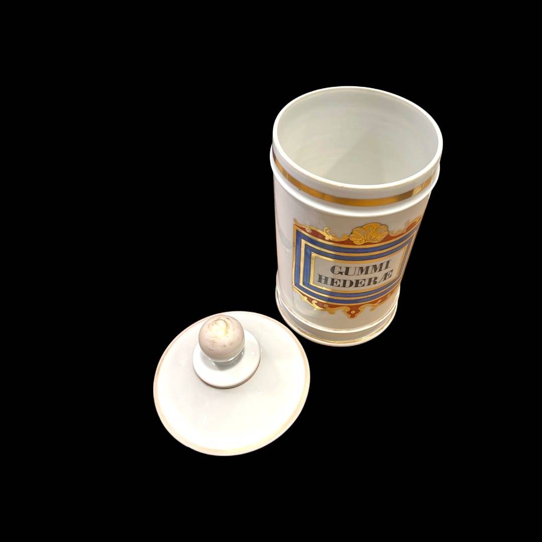 Albaredo de cerámica antigua abierto con tapa retirada, etiqueta 'Gummi Hederæ', decoración clásica para amantes de la botánica y farmacia.