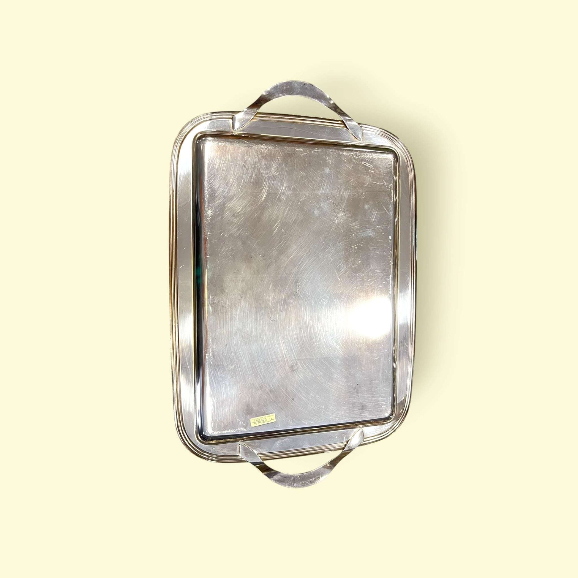 Bandeja de metal plateado antigua con asas laterales.