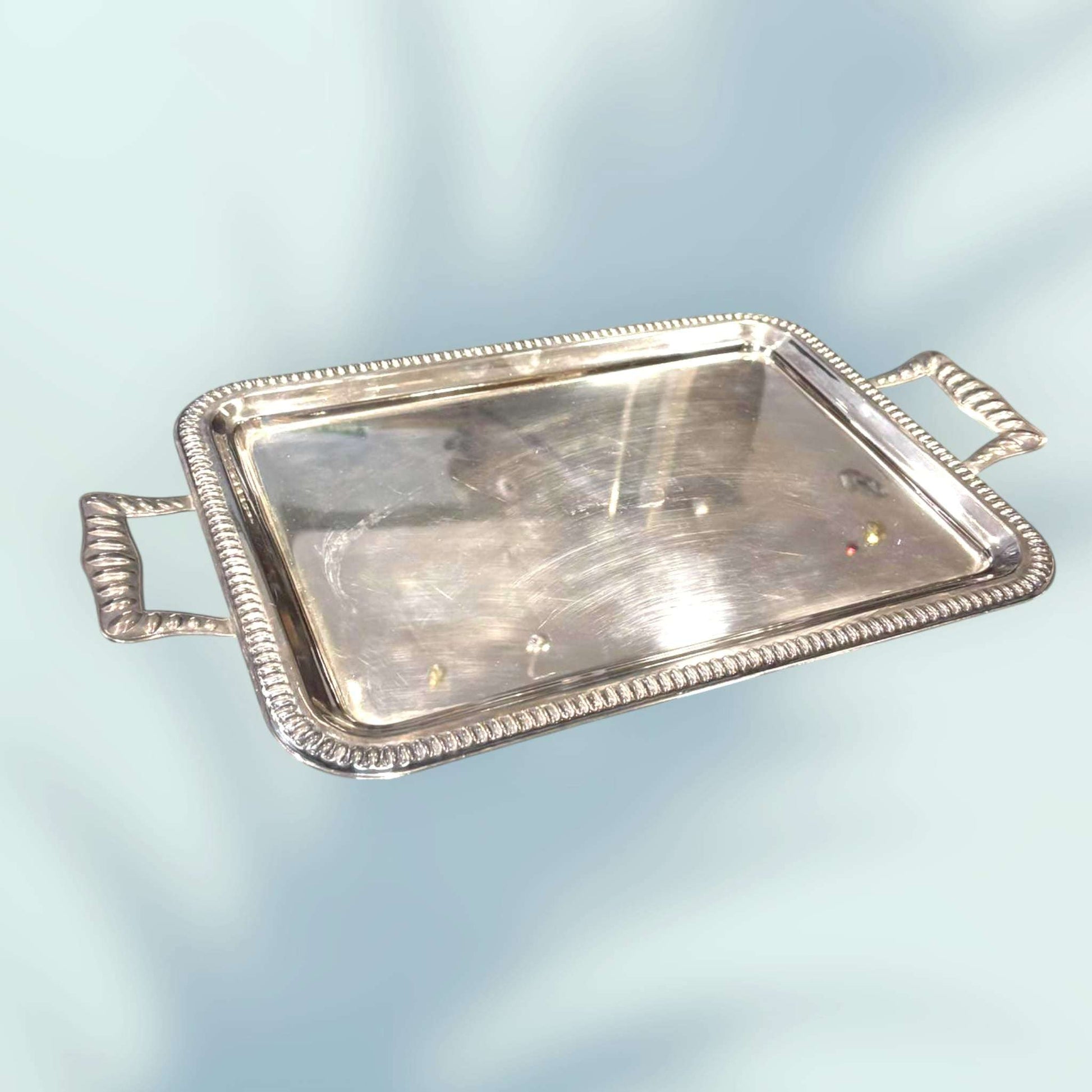 Fotografía lateral de bandeja plateada con borde estriado.