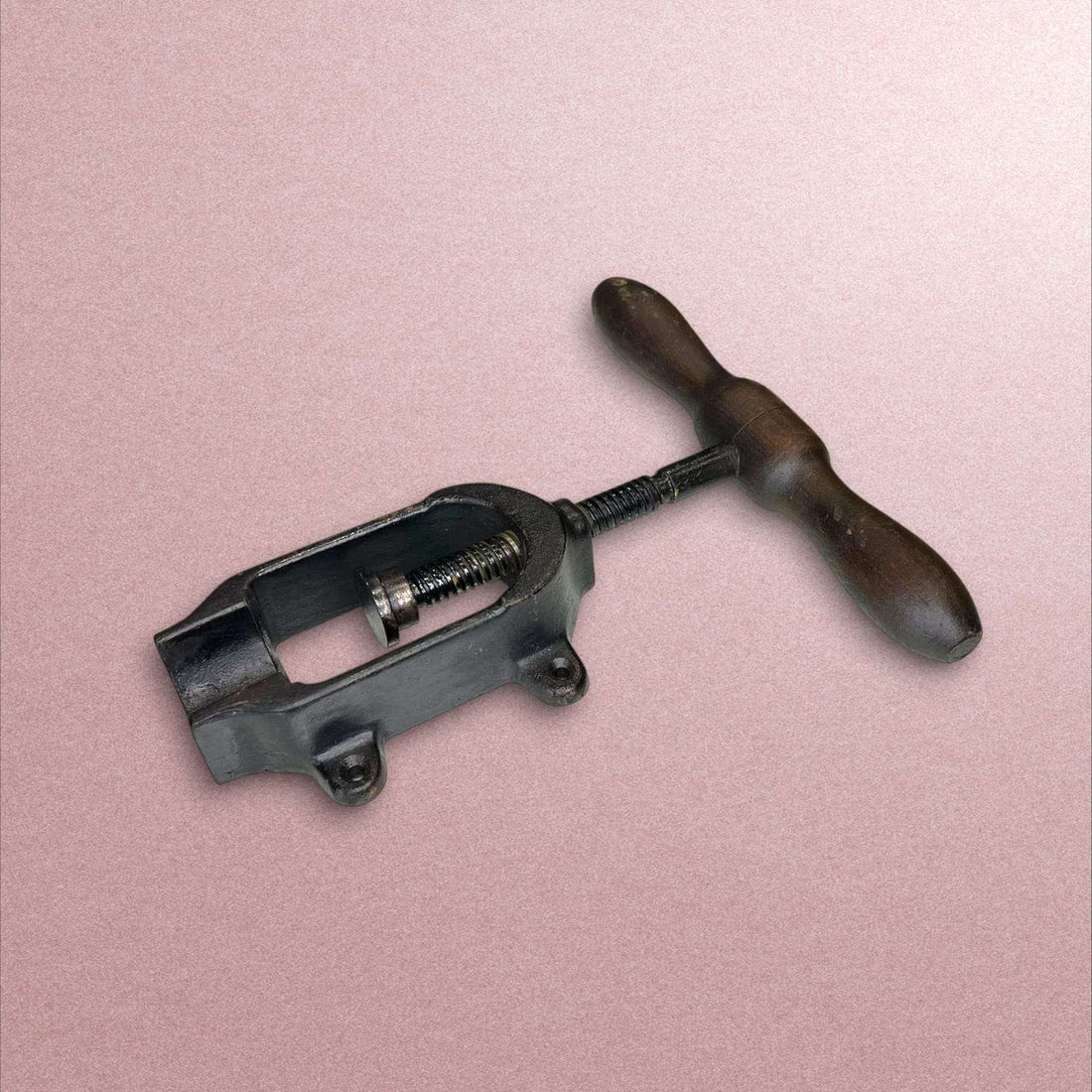 Cargador de cartuchos antiguo con mango de madera y cuerpo metálico.