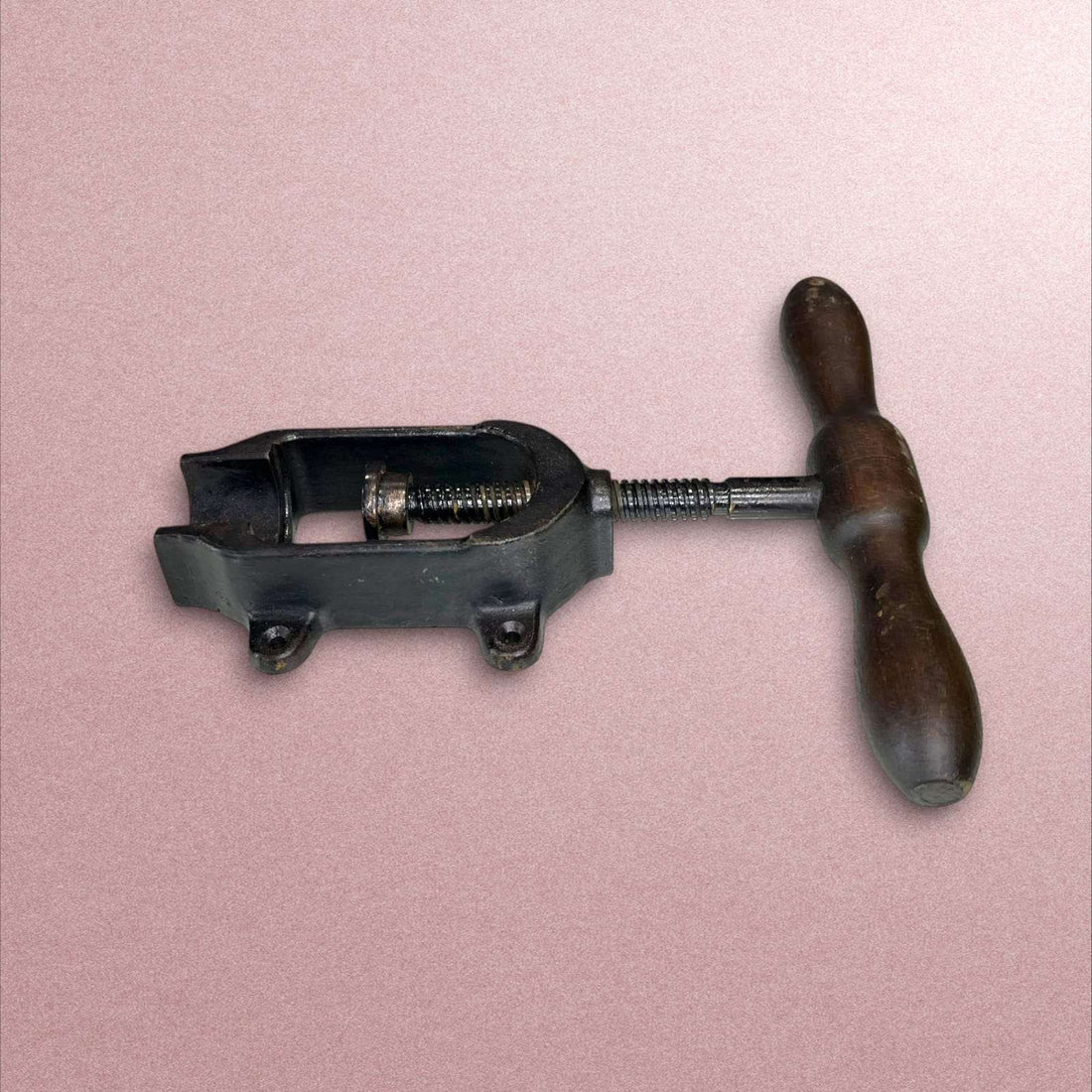 Cargador de cartuchos antiguo con mango de madera y cuerpo metálico.