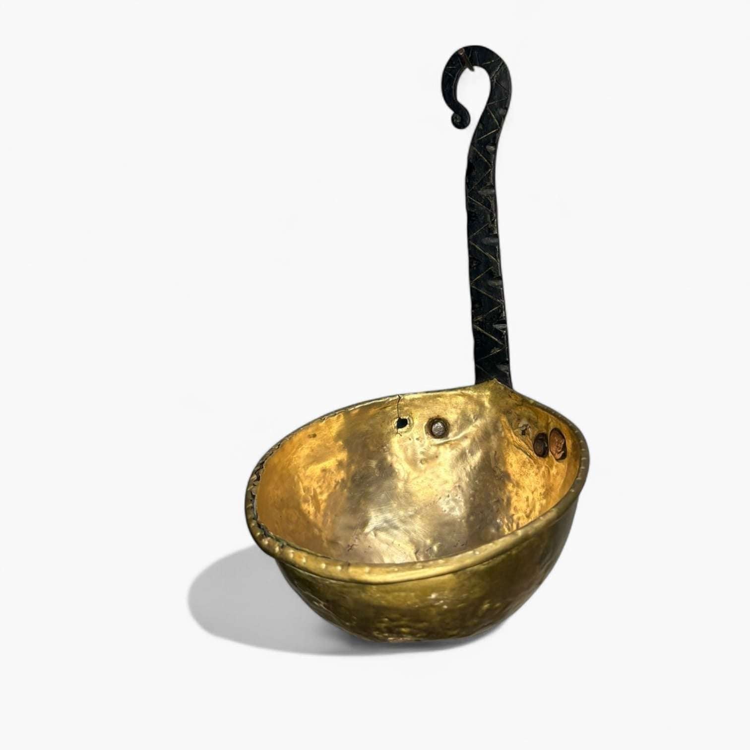 Cazo decorativo de metal dorado con mango de hierro negro ornamentado, pieza única para decoración de hogar estilo vintage o rural.