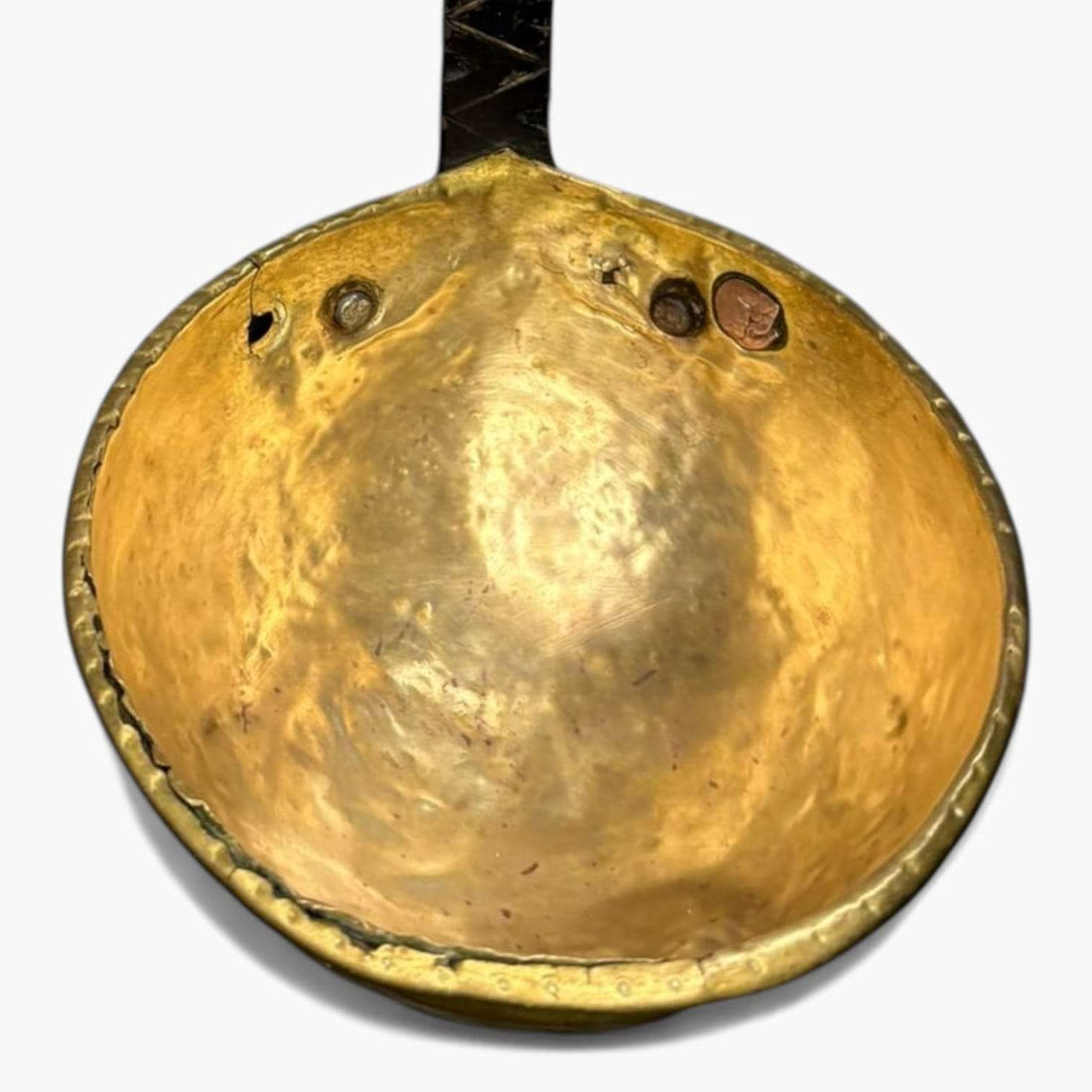 Cazo antiguo de metal dorado con mango de hierro forjado en forma curva, ideal para decoración rústica en cocina o colección vintage.