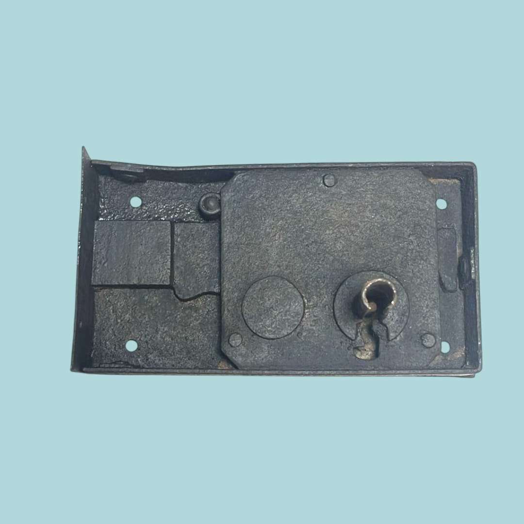 Vista frontal de la cerradura antigua de forja mostrando su diseño artesanal.