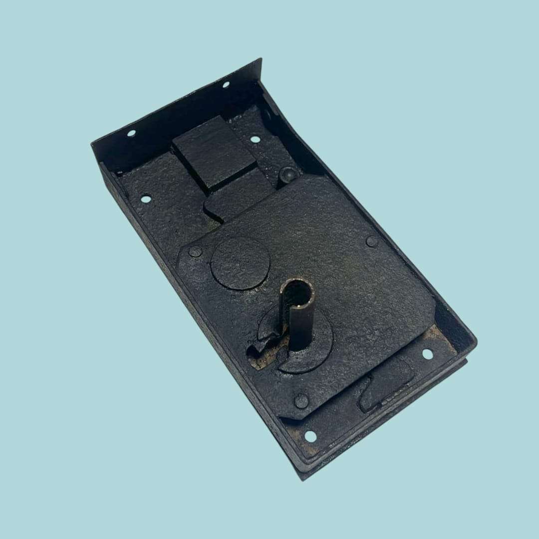 Perspectiva diagonal de la cerradura antigua de forja resaltando el relieve.