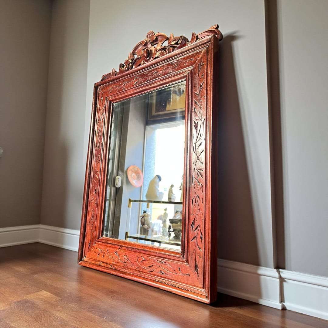 Espejo de caoba antiguo con marco tallado a mano.