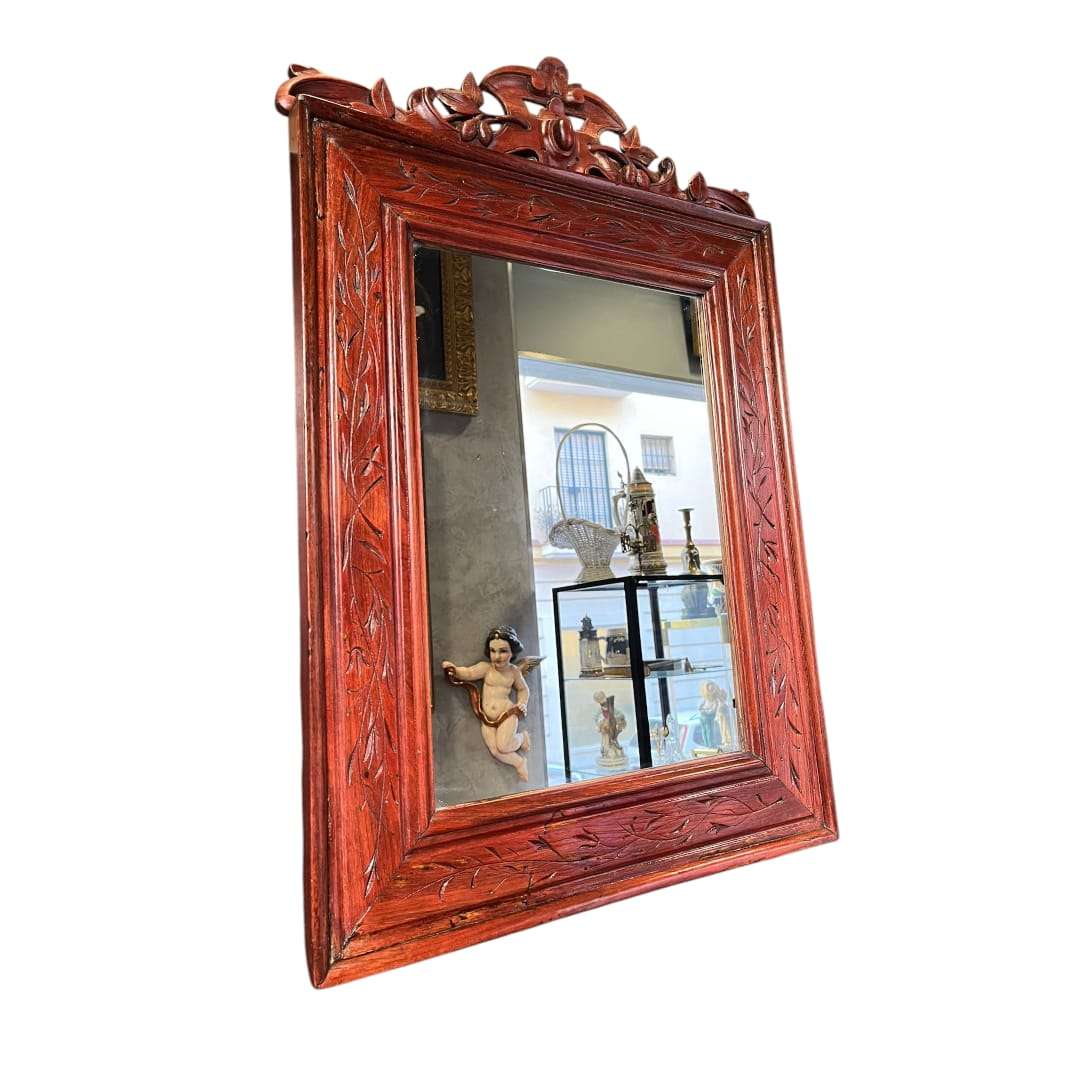 Espejo de caoba antiguo con marco tallado a mano.