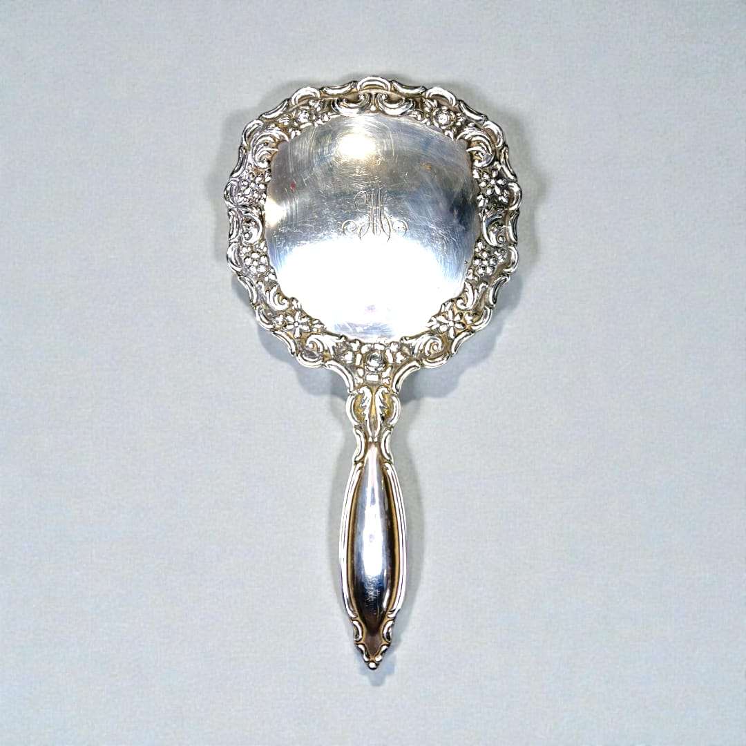 La parte trasera metálica presenta grabados sutiles que añaden carácter, mientras que el cristal muestra un brillo limpio y auténtico que refleja su historia. 