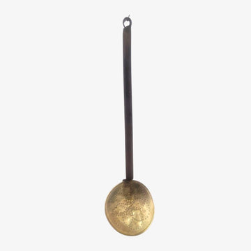 Espumadera con mango de hierro y cabezal de metal dorado, ideal para decoración vintage en cocina o pared. Diseño rústico y funcional.