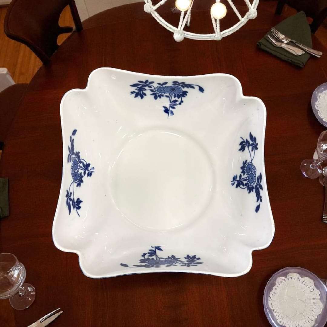 ta superior del frutero cuadrado con bordes ondulados y flores azules.