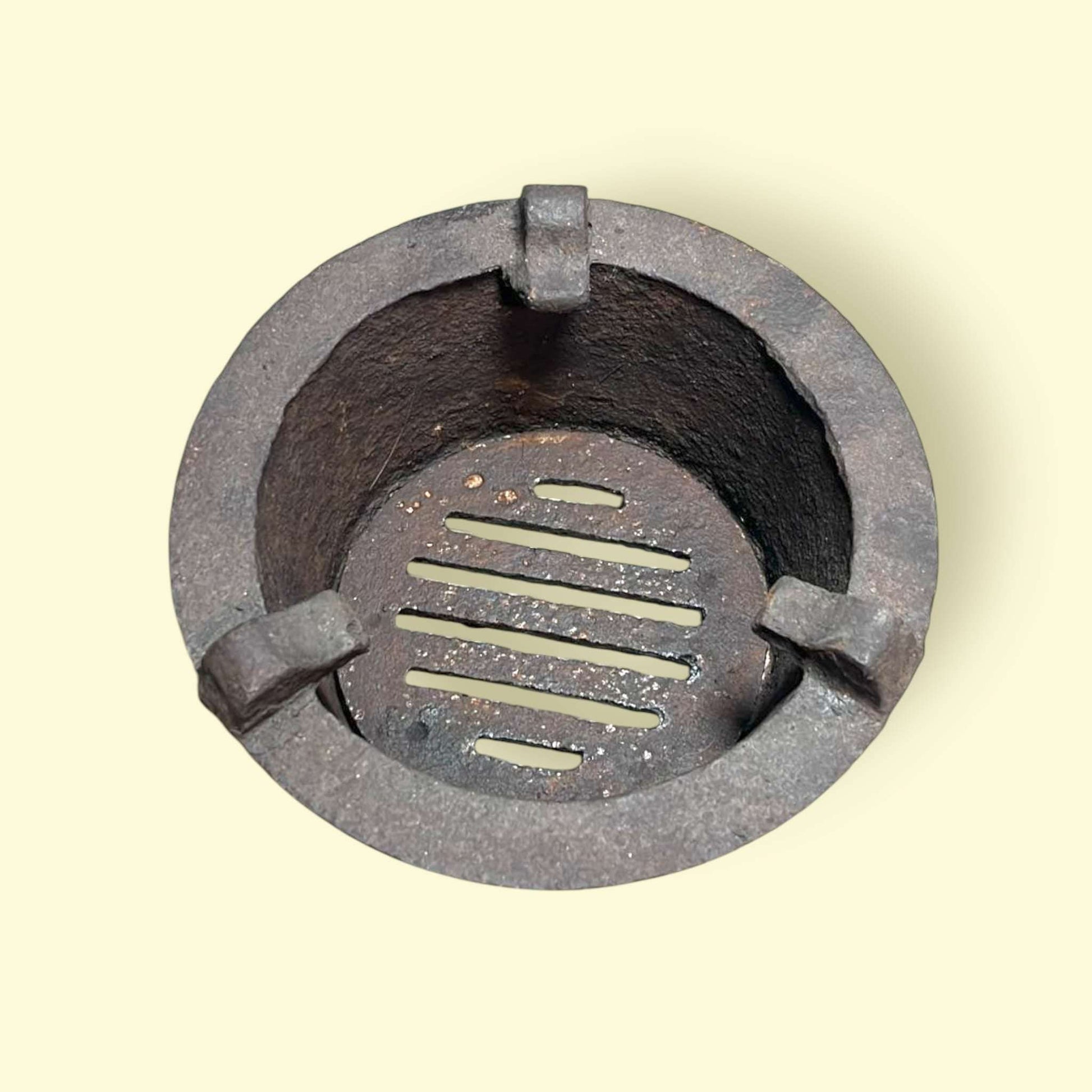 Detalle de hornilla de carbón retro, metal resistente con acabado original.