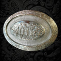 Bandeja decorativa ovalada en cobre plateado con diseño renacentista y escena de batalla en relieve. Ideal para añadir sofisticación al hogar.
