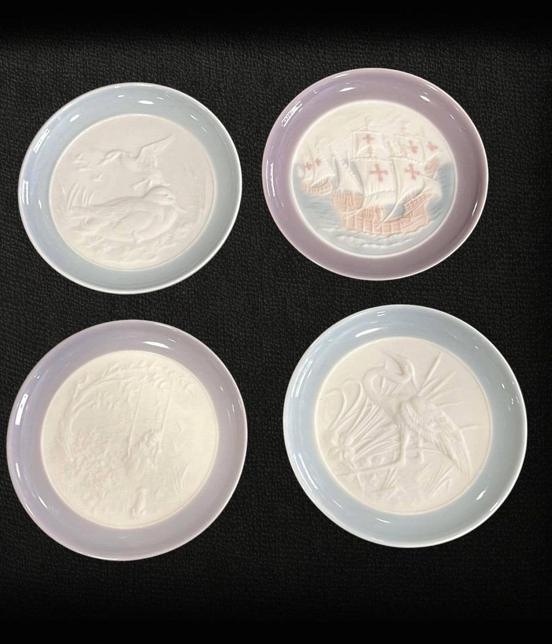 Conjunto Platos Lladro de cerámica 1993 con relieves artísticos de aves, barcos y escenas naturales. Decoración de lujo para el hogar.