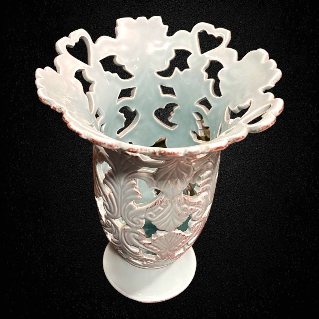 Florero calado en porcelana celeste con diseño floral y bordes ondulados. Ideal para decoración elegante en interiores de estilo clásico.