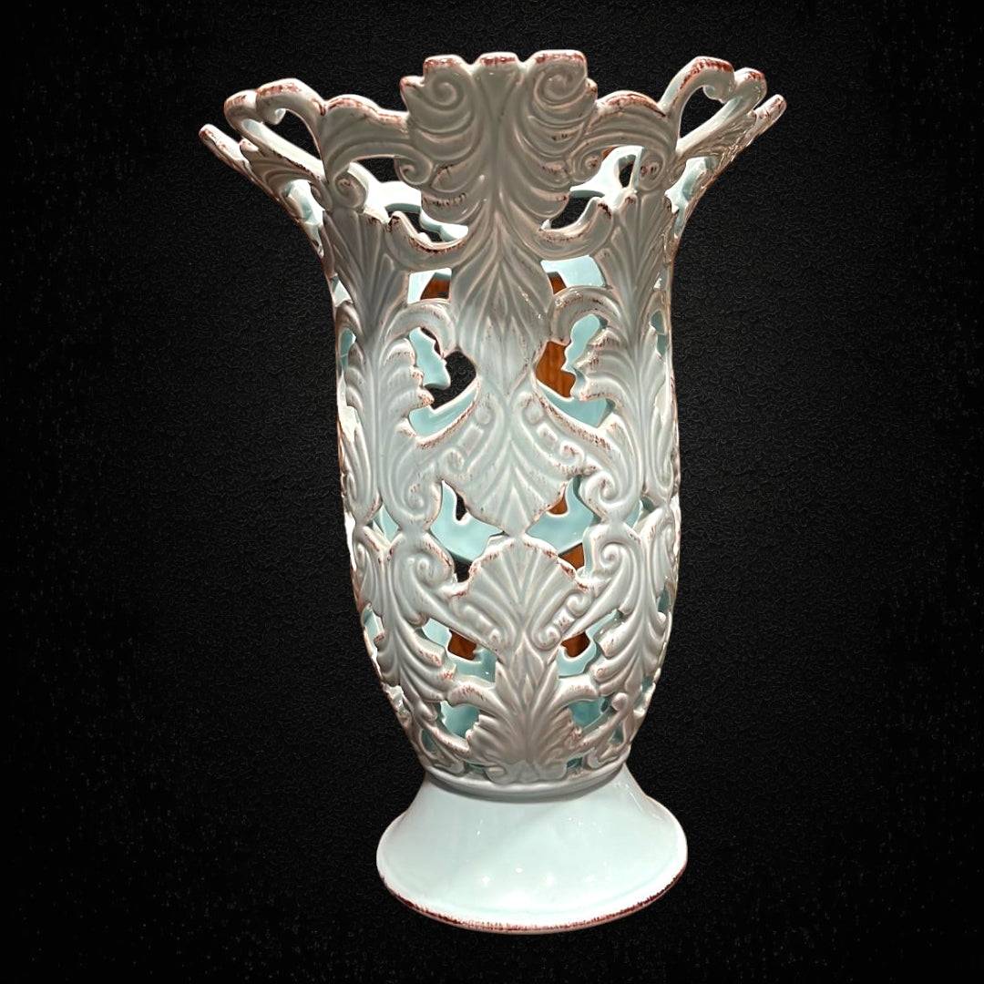 Florero calado en porcelana celeste con diseño floral y bordes ondulados. Ideal para decoración elegante en interiores de estilo clásico.