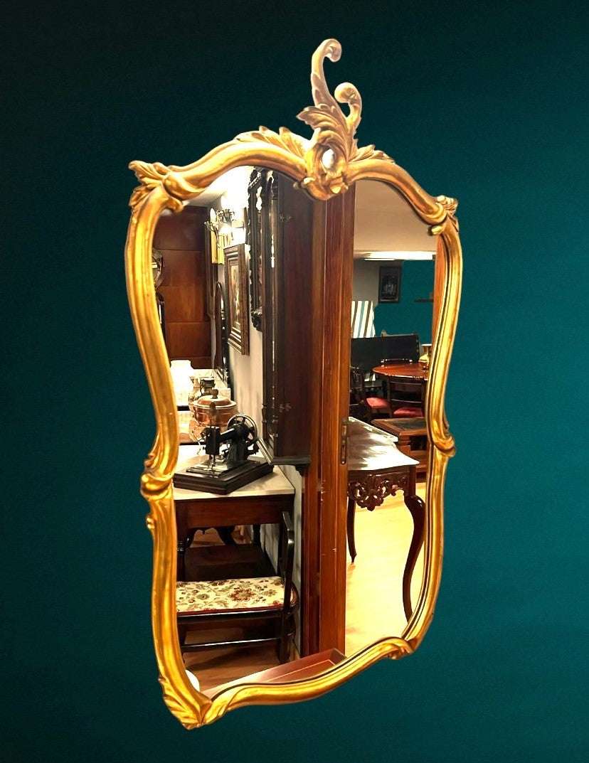 Espejo antiguo dorado con marco ornamentado y acabado brillante, ideal para decoración de interiores clásicos. Aporta elegancia y estilo al hogar.