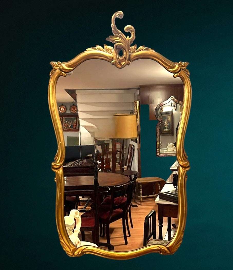 Espejo antiguo dorado con marco ornamentado y acabado brillante, ideal para decoración de interiores clásicos. Aporta elegancia y estilo al hogar.