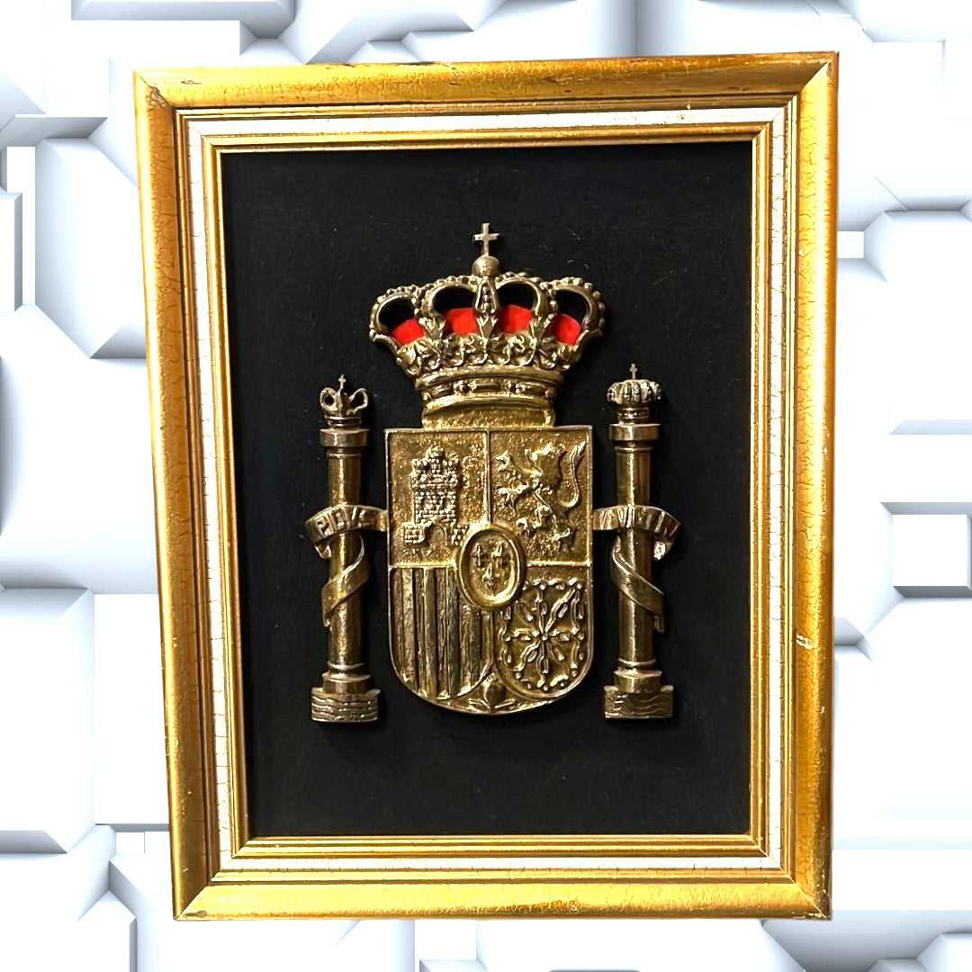 Cuadro decorativo del Escudo de España en metal dorado con fondo negro y marco dorado, ideal para mostrar orgullo nacional en el hogar.