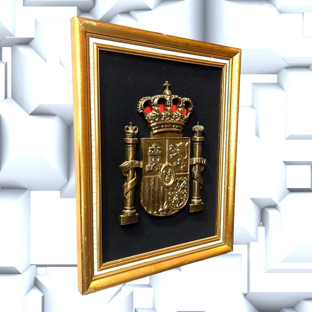 Cuadro decorativo del Escudo de España en metal dorado con fondo negro y marco dorado, ideal para mostrar orgullo nacional en el hogar.