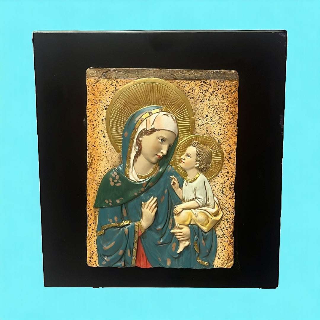 Relieve de la Virgen María y Jesús en resina sobre fondo negro, ideal para decoración espiritual del hogar. Imagen sagrada con detalles dorados.
