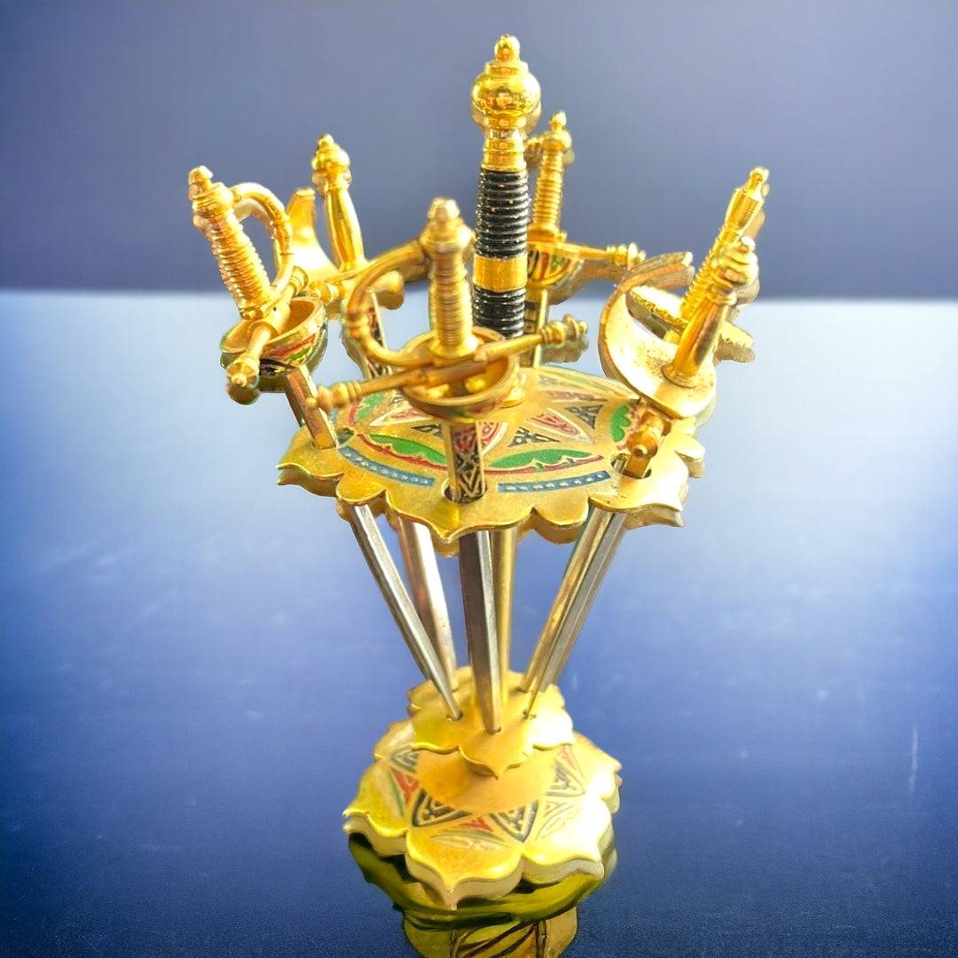 Palillero Real Fábrica Toledo - Lujo en metal dorado con diseño de espadas decorativas. Ideal para decoración de mesa elegante en el hogar.