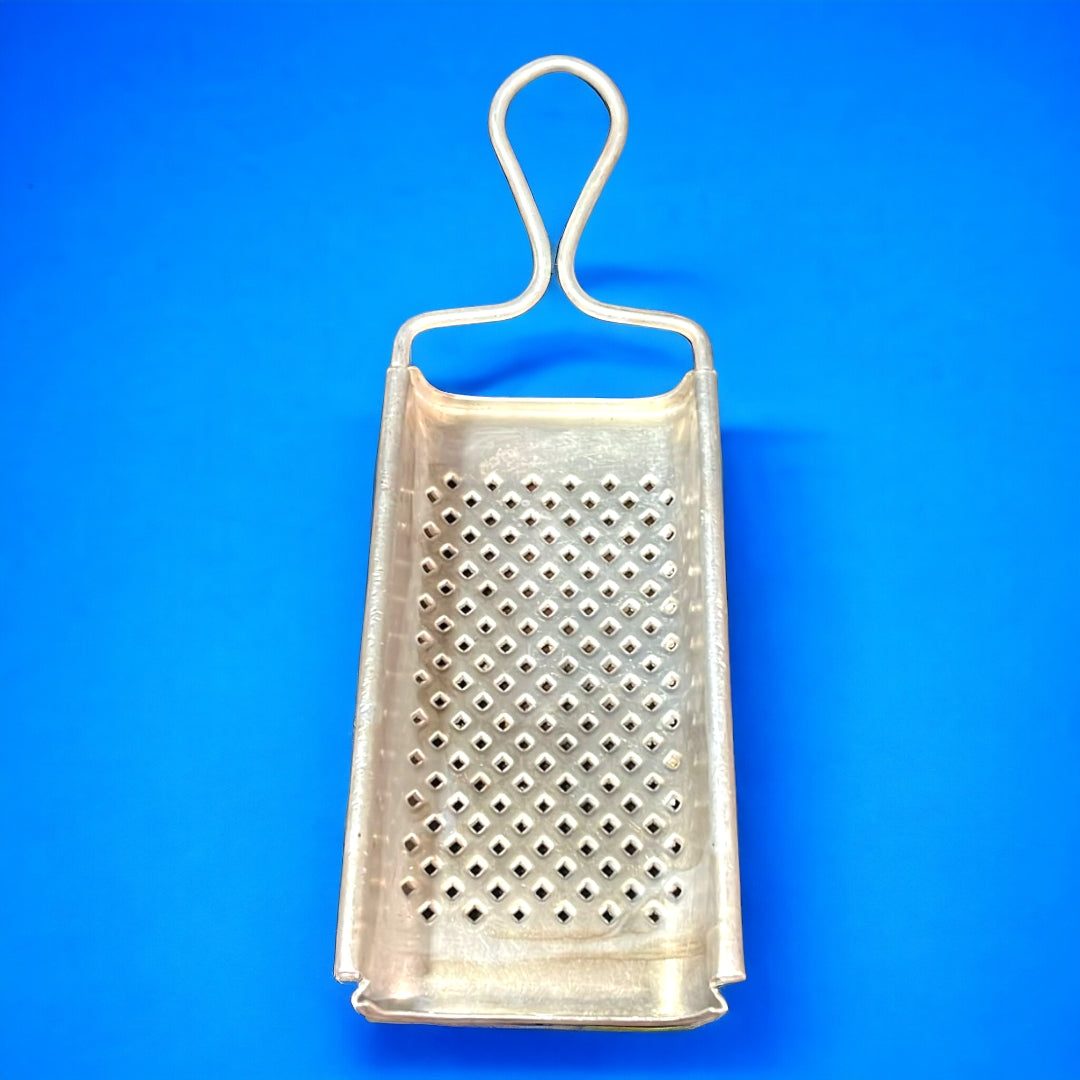 Rayador antiguo de aluminio con diseño clásico para cocina. Ideal para rallar ingredientes y decorar espacios con un toque vintage.