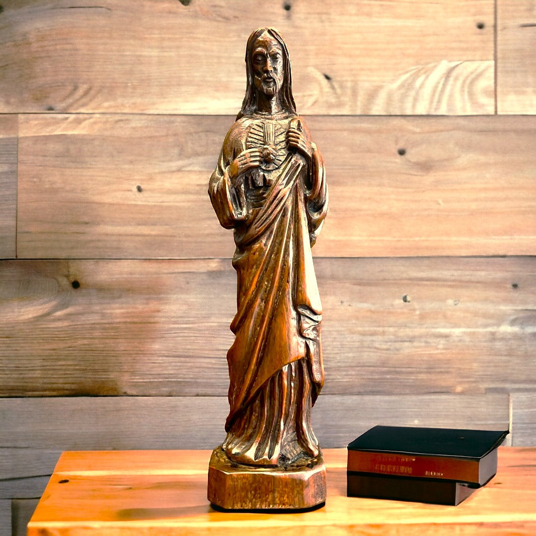 Sagrado Corazón de Jesús tallado en madera, ideal para decoración religiosa en el hogar. Imagen con fondo de madera para un ambiente cálido.