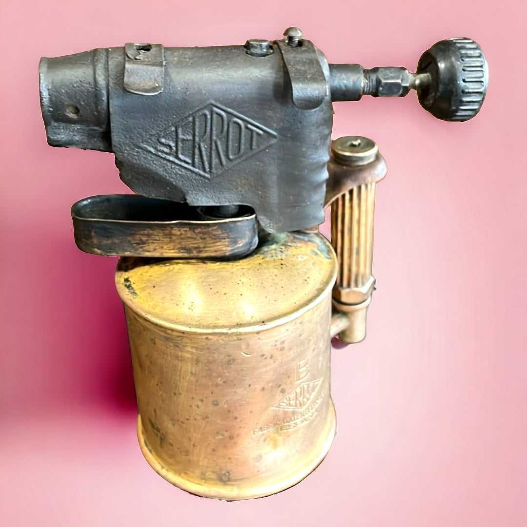 Soplete de fontanero de metal marca Serrot con acabado vintage, ideal para decoración industrial en el hogar o colección de herramientas antiguas.